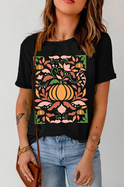 Woman wearing graphic round neck short sleeve t-shirt with colorful pumpkin and floral design.