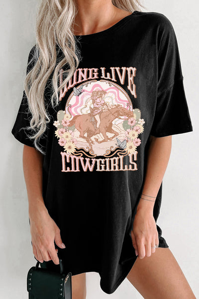 Woman wearing black graphic round neck half sleeve oversize t-shirt featuring "Long Live Cowgirls" design with floral accents.