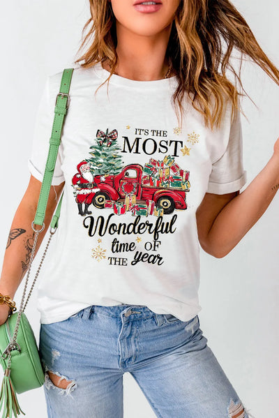 Woman wearing a graphic round neck short sleeve t-shirt featuring holiday design with red truck and festive text, paired with ripped jeans.