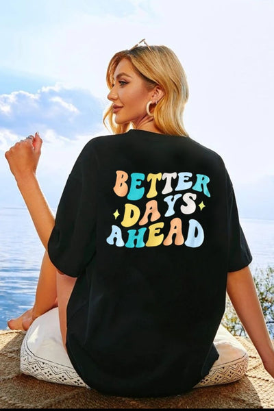 Woman wearing a "BETTER DAYS AHEAD" round neck t-shirt, ocean view background.