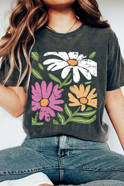 Woman wearing a flower graphic round neck short sleeve t-shirt in dark color, featuring pink, white, and yellow flowers; casual style.