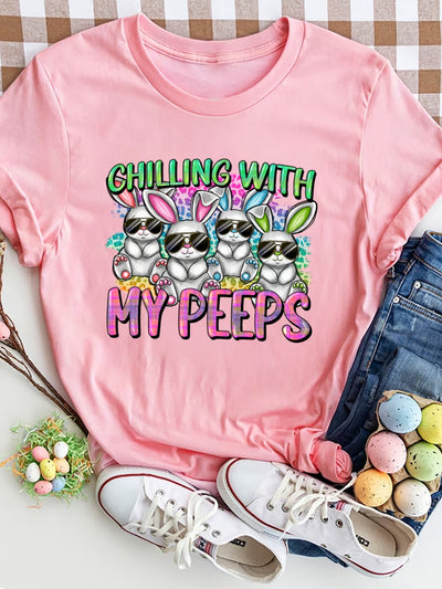 Pink "Chilling with My Peeps" round neck t-shirt with bunny graphics, displayed with jeans, sneakers, and Easter eggs.