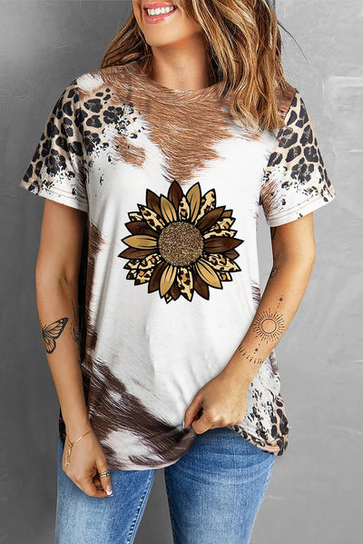 Woman wearing sunflower graphic round neck short sleeve t-shirt with animal print design, paired with blue jeans.